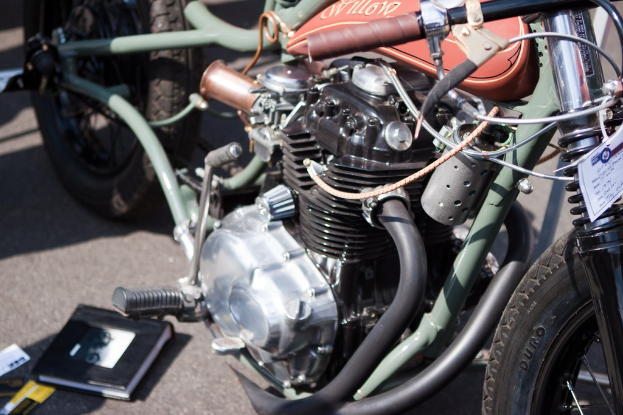 Mehrere Motorräder neben einem Buch auf dem Boden geparkt.