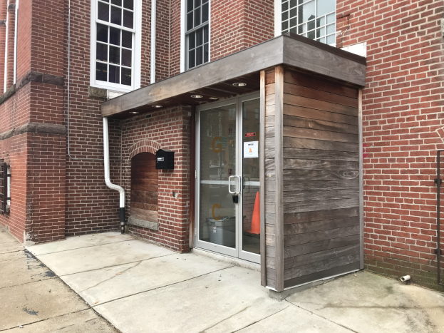 Ziegelgebäude mit einer Glastür und Fenstern, Rohren und einem "Feuerwache"-Schild, das renoviert wird.