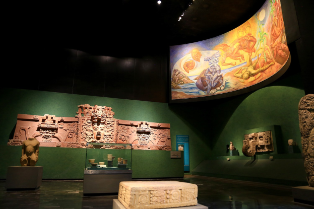 Ausstellung verschiedener Artefakte im Mexiko-Stadt-Museum der Anthropologie, darunter Skulpturen, Tischobjekte, eine Texttafel, eine Wandmalerei und Deckenleuchten.