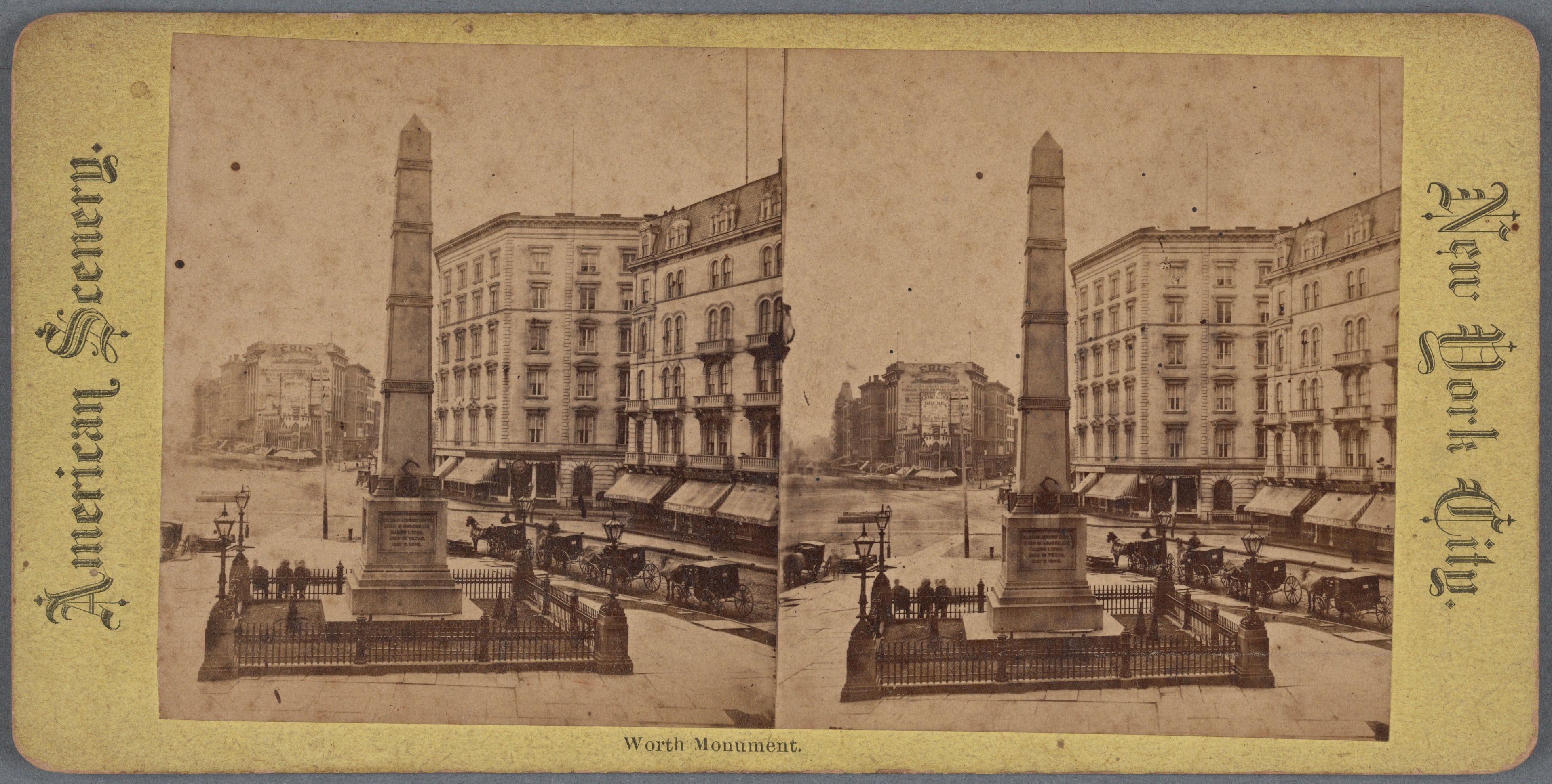 Altes Schwarz-Weiß-Foto einer Stadtstraße mit einem zentralen Denkmal umgeben von Gebäuden, Straßenmöbeln, Fahrzeugen, Passanten und einem sichtbaren Himmel.