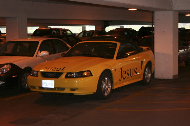 Ein Parkplatz voller geparkter Autos vor einem Gebäude.