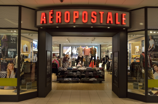 Aeropostale-Laden im Einkaufszentrum mit Schaufensterpuppen in Kleidern, Kleiderständern, Infotafeln, Glaswänden, Beleuchtung und Hinweisschildern auf Schließung im Juni.