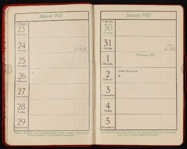 Offenes deutsches Tagebuch von 1927 mit Kalender obenauf, vor dunklem Hintergrund dargestellt.