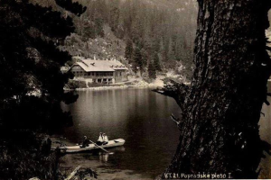 Ein Schwarz-Weiß-Foto von zwei Menschen in einem Kanu auf einem See, umgeben von Bäumen und einem Haus im Hintergrund, aufgenommen in Popradskie, Polen, in den 1920er Jahren.