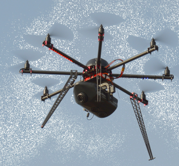 Eine schwarze Drohne mit einer Kamera fliegt durch die Luft vor einem wei├čen Hintergrund.