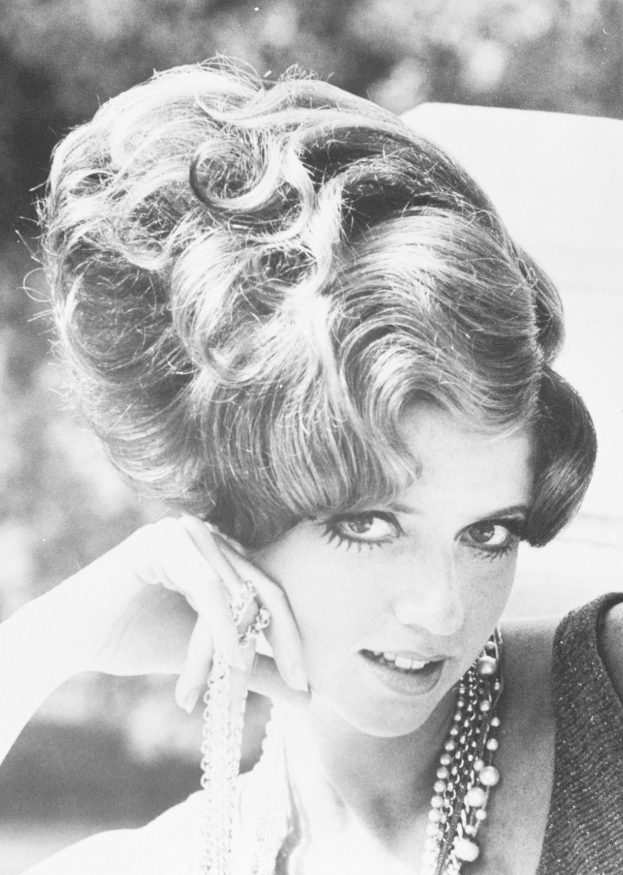Schwarzes und wei├čes Foto von Prinzessin Diana in einem Kleid und Schmuck mit einem unscharfen Hintergrund.