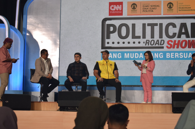 Eine Gruppe von Menschen auf einer Bühne mit einigen vorne auf dem Podium stehend und ein Schild im Hintergrund mit der Aufschrift "Cnn Political Road Show".